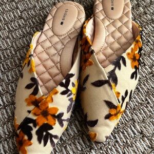 Birdies The Swan Slides in Marigold yellow print on a velvety backdrop.